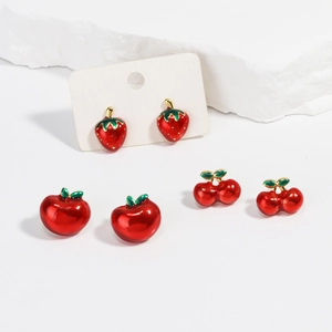 Détail de boucles d'oreilles émaillées en forme de fraise, pomme et cerise avec métal doré