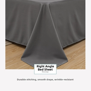 Close-up of dark grey washed cotton flat sheet draping over a wooden floor corner