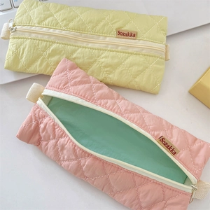 Detailed view of quilted pencil pouch featuring diamond stitching and soft fabric texture