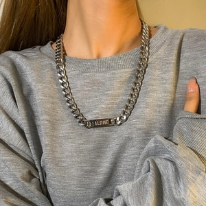 Silver cuban chain necklace with engraved Aline rectangle tag on a male model
