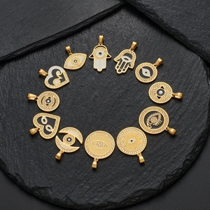 Golden stainless steel cross and evil eye pendant charms collection on black stone base