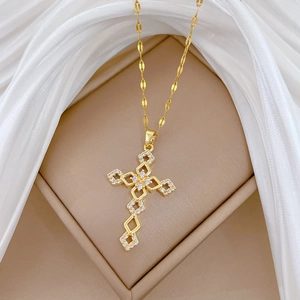 Elegant gold cross necklace with shimmering cubic zirconia on white silk background