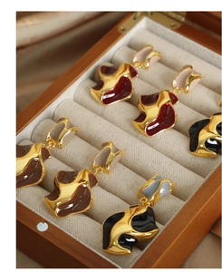 Detail of irregular wave enamel earrings in five colors displayed in a wooden box