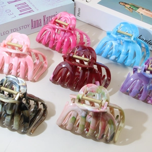 Detail view of colorful ABS flower hair claws in various shades with marble patterns