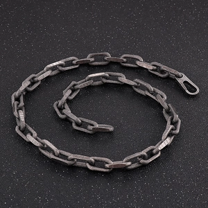 Macro shot of dark grey paperclip chain necklace with textured links and carabiner clasp