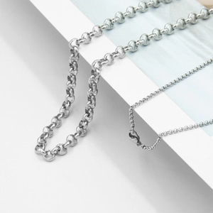Close-up of silver stainless steel thick link chain and thin bead necklace with clasps