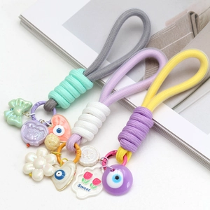 Détail de porte-clés tissés colorés avec des breloques en forme de cœur et de fleur