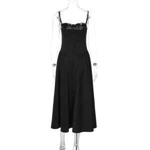 Detail view of backless black midi dress showing waist-cinching and spaghetti strap design