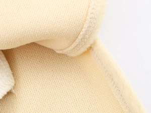Close-up of light yellow knit fabric featuring a soft fleece lining and neat stitching