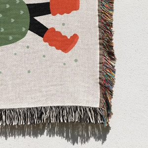 Detailed close-up of woven Christmas tree blanket edge featuring colorful tassels and texture