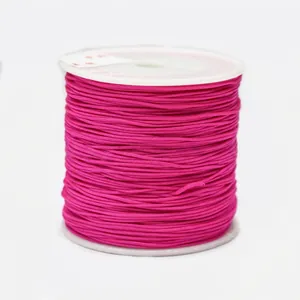 Macro detail of rose red 0.8mm nylon cord spool for manual jewelry braiding and crafts