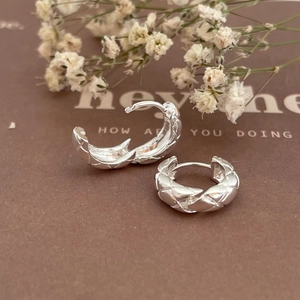 Elegant 925 sterling silver hoop earrings with quilted pattern on a minimalist backdrop