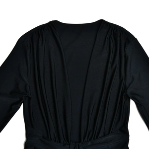Vue détaillée du décolleté en V profond et du plissage élégant sur cette robe noire