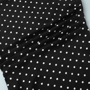 Close-up of black and white polka dot chiffon fabric with soft elegant draping