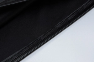 Detail view of the fine stitching and woven texture on this black PU leather skirt set