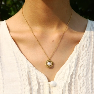 Vintage 18K gold-plated twisted spiral pendant necklace with a center pearl on a model