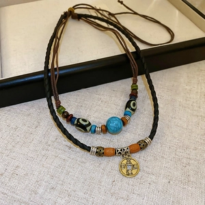 Macro shot of ethnic layered necklace with turquoise beads and ancient coin pendant