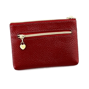 Close-up of red genuine leather coin purse with lychee texture and gold heart pendant