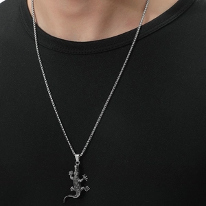 Close-up of vintage silver crocodile pendant necklace worn by male model on black t-shirt
