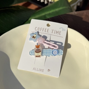 Detail of sweet star and plaid hair clips with coffee bear motif on display card