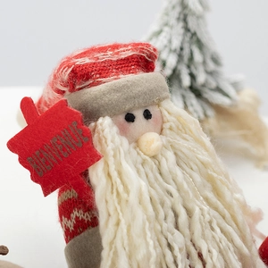 Festive Santa figurine with knitted hat holding a Welcome sign for Christmas decoration