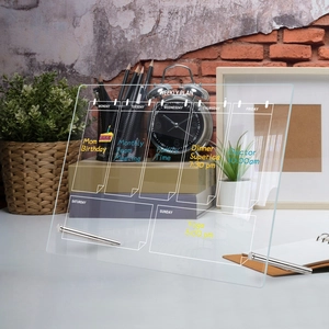 Detailed view of an acrylic weekly planner on desk with metal supports and handwritten notes