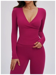 Detail of V-neck wrap yoga top and high waist leggings in plum purple stretch fabric