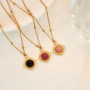Detailed shot of three gold sunburst necklaces featuring colorful natural stone pendants