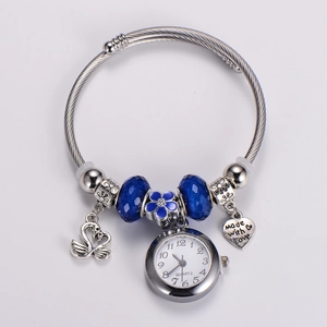 Detail of quartz watch bracelet with blue enamel flower and swan charms in silver