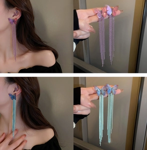 Detalle de pendientes largos de flecos con mariposas en degradado rosa y azul