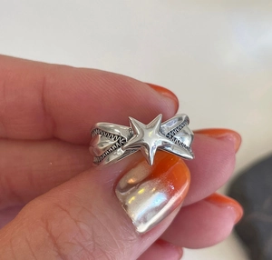 Detail of 925 sterling silver star ring with engraved sunburst texture on band