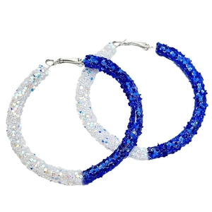 Macro detail of large hoop earrings with sparkling blue and white glitter finish