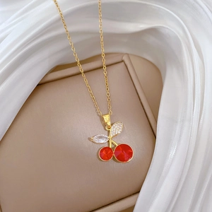 Close-up of a luxury red cherry pendant necklace with crystals on gold chain