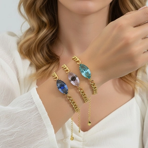 Detailansicht dreier goldener Gliederketten mit blauen und lila Kristallen im Marquise-Schliff
