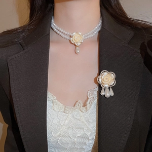Vue détaillée du collier de perles à double rang et broche florale avec strass élégants