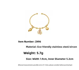 Detail of 18k gold plated stainless steel cuff with shell and octopus charms