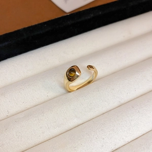 Nahaufnahme des vergoldeten verstellbaren Rings mit poliertem Band und braunem Edelstein