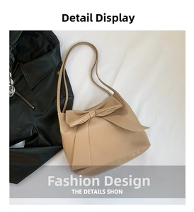 Detail of a beige leather tote bag with a large decorative bow and slim straps
