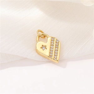 Close-up of golden micro-pave zircon heart pendant with star motif on white fabric