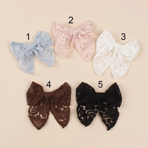 Detailed view of five lace bow hair clips in blue, pink, white, brown, and black colors