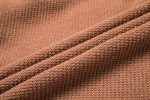 Macro view of brown knit cardigan showing high-density fabric texture and soft wool fibers