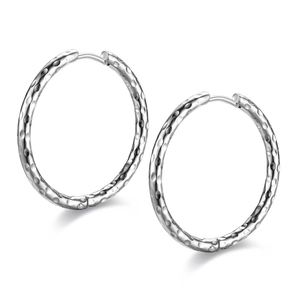 Close-up of silver titanium steel hoop earrings with unique hammered texture design