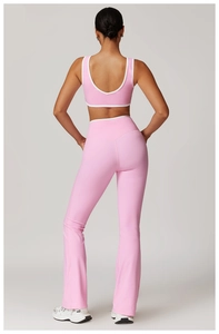 Detail of pink sports set featuring white contrast trim and high-waist flared yoga pants