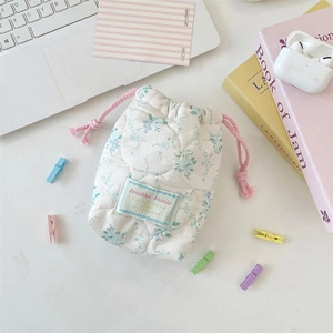 Macro shot of quilted floral drawstring storage bag with soft cotton texture and pink cord
