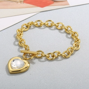 Detail of gold chain bracelet with clear heart crystal pendant and toggle clasp