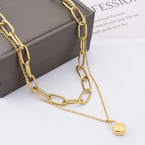 Gold-layered necklace with chunky paperclip chain and heart padlock charm on box