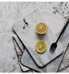 Detailed view of rectangular ceramic tray with grey marble texture and gold rim edging
