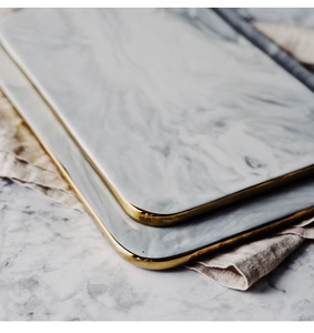 Detail of Nordic marble pattern ceramic tray with elegant gold-rimmed edges