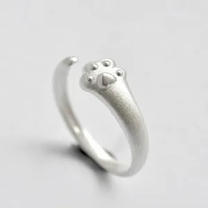 Detailed close-up of matte silver open ring featuring a cute cat paw design element