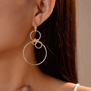 Modern geometric multi-loop drop earrings in gold and silver finish on female model